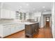 Bright kitchen featuring white cabinetry, granite countertops, and an island with a cooktop and marble countertop at 2238 Lakeview Ter, Burlington, NC 27215