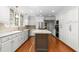 Bright kitchen featuring white cabinetry, granite countertops, stainless steel appliances and a dark kitchen island at 2238 Lakeview Ter, Burlington, NC 27215