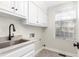 Bright laundry room featuring white cabinets, light granite countertop, stainless steel sink and natural light at 2238 Lakeview Ter, Burlington, NC 27215