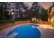 Back exterior featuring a private in-ground pool, diving board, brick retaining wall, and wooded perimeter at 2238 Lakeview Ter, Burlington, NC 27215