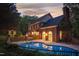 Back exterior featuring a private in-ground pool, brick retaining wall, and wrought iron fencing at sunset at 2238 Lakeview Ter, Burlington, NC 27215