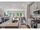 Modern kitchen with stainless steel appliances, white cabinets, and an open floorplan leading to dining and living areas at 244 Paramount Dr # 24, Smithfield, NC 27577