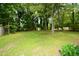 Expansive backyard with lush green grass and mature trees, providing a serene outdoor space at 2805 Nc 55, Durham, NC 27713