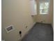 Functional laundry room with speckled floor, a window for natural light, and hookups for laundry appliances at 2805 Nc 55, Durham, NC 27713