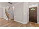 Inviting entryway featuring a wooden front door, staircase, and light hardwood flooring at 3002 Remington Oaks Cir, Cary, NC 27519