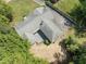 An aerial shot showcases the backyard patio and roof of a large home surrounded by greenery at 306 Holland Rd, Fuquay Varina, NC 27526