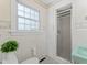 Clean bathroom with a white-tiled shower, toilet, and sink with a bright window at 306 Holland Rd, Fuquay Varina, NC 27526