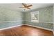 Bedroom featuring hardwood floors, a ceiling fan, and a large window offering natural light at 306 Holland Rd, Fuquay Varina, NC 27526