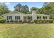 Charming white brick home with black shutters and a well-manicured front lawn and stone walkway at 306 Holland Rd, Fuquay Varina, NC 27526