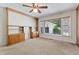 Living room boasts built-in wooden shelving, neutral carpet, and a ceiling fan for comfortable living at 306 Holland Rd, Fuquay Varina, NC 27526