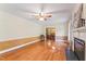 Spacious living room with hardwood floors, fireplace, view to dining room, ceiling fan and large windows at 306 Holland Rd, Fuquay Varina, NC 27526