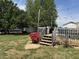Exterior backyard with wooden deck featuring multiple grills, flowers, and a lush green lawn at 309 Westfield Dr, Dunn, NC 28334