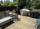 Wooden deck area featuring multiple grills with lush greenery and a brick fence at 309 Westfield Dr, Dunn, NC 28334