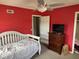 Bedroom featuring red walls, carpeted floors, windows, a bed, dresser, and closet at 309 Westfield Dr, Dunn, NC 28334
