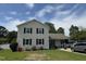 Two-story home with cream siding, black shutters, and a boat parked in the driveway at 309 Westfield Dr, Dunn, NC 28334