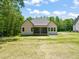 Rear view of a single-Gathering home exterior and well maintained lawn at 310 Pilot Ridge Rd, Zebulon, NC 27597