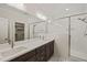 Modern bathroom features a double sink vanity, large mirror, and glass-enclosed shower with elegant tile work at 310 Pilot Ridge Rd, Zebulon, NC 27597