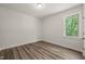 Cozy bedroom featuring wood-look flooring, a window with nature view, and neutral wall paint at 310 Pilot Ridge Rd, Zebulon, NC 27597