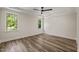 Spacious bedroom features a ceiling fan, tray ceiling, wood plank flooring and many windows at 310 Pilot Ridge Rd, Zebulon, NC 27597
