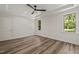 Bright bedroom boasts wood-look flooring, tray ceiling with fan, and plenty of natural light from two windows at 310 Pilot Ridge Rd, Zebulon, NC 27597