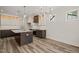Open kitchen is complete with a functional island, stainless steel appliances, and wood plank flooring at 310 Pilot Ridge Rd, Zebulon, NC 27597