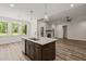Bright living room features a modern chandelier, wood plank flooring, and direct access to outdoor views at 310 Pilot Ridge Rd, Zebulon, NC 27597