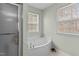 Bright bathroom with tile floors, shower and separate soaking tub next to windows at 338 Howland Ct, Creedmoor, NC 27522