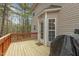 View of the wooden deck, complete with outdoor grill, set against a backdrop of lush trees and natural surroundings at 338 Howland Ct, Creedmoor, NC 27522