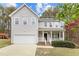 Charming two-story home with a white picket porch, attached garage, and manicured lawn at 338 Howland Ct, Creedmoor, NC 27522