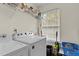 Efficient laundry room with white appliances, shelving, and ample natural light at 338 Howland Ct, Creedmoor, NC 27522