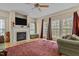 Comfortable living room features a fireplace, large windows, and neutral decor with a ceiling fan at 338 Howland Ct, Creedmoor, NC 27522