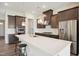 Modern kitchen boasting dark cabinets, stainless steel appliances, and an island with seating for casual dining at 3510 Tuftonboro Ln, Apex, NC 27502