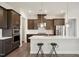 Well-equipped kitchen featuring dark cabinets, stainless steel appliances, and a large center island with seating at 3510 Tuftonboro Ln, Apex, NC 27502