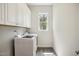 Bright laundry room with washer, dryer, white cabinets and window at 3510 Tuftonboro Ln, Apex, NC 27502