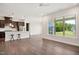 Open-concept living room with wood floors, recessed lights, and a kitchen featuring dark cabinets and an island at 3510 Tuftonboro Ln, Apex, NC 27502