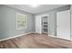 This bedroom includes wood-look flooring, a window, a closet, and a neutral paint at 401 Crestview Dr Dr, Durham, NC 27712