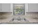 Bright kitchen features stainless steel sink, neutral tile backsplash, and window with natural light at 401 Crestview Dr Dr, Durham, NC 27712