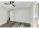 A bright bedroom featuring stylish gray flooring, a ceiling fan, and ample natural light from a nearby window at 434 Robin Rd, Chapel Hill, NC 27516