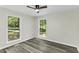Sunlit bedroom boasts two large windows offering serene views, complemented by modern flooring and neutral walls at 434 Robin Rd, Chapel Hill, NC 27516