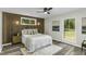Charming bedroom with wood-paneled accent wall, stylish fan, and windows with views at 434 Robin Rd, Chapel Hill, NC 27516