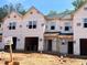 Three-story townhome under construction with visible framing and a two-car garage at 45 Calluna Dr, Clayton, NC 27520