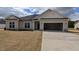 Charming single-story home with a two-car garage, neutral siding, and stone accents under a cloudy, blue sky at 457 Sweet Potato Lane # 13, Nashville, NC 27856