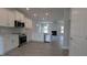 Bright kitchen boasts white cabinets, stainless steel appliances, modern countertops, and open layout to the living room at 457 Sweet Potato Lane # 13, Nashville, NC 27856