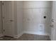 Functional laundry room with overhead shelving, washer/dryer hookups, and durable tile flooring for convenience at 457 Sweet Potato Lane # 13, Nashville, NC 27856