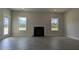 Spacious living room featuring a fireplace, windows, and gray flooring, creating a bright and airy atmosphere at 457 Sweet Potato Lane # 13, Nashville, NC 27856