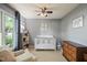 Cozy Bedroom with a crib, dresser, and a comfortable armchair by the window at 4969 Royal Adelaide Way, Raleigh, NC 27604