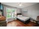 Bedroom with hardwood floors, ceiling fan, and window with view of the backyard at 4969 Royal Adelaide Way, Raleigh, NC 27604