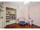 Bedroom with hardwood floors, closet, shelving, and a fun pink color scheme at 4969 Royal Adelaide Way, Raleigh, NC 27604