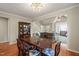 Dining room with modern lighting, view of the living room, and hardwood floors creating an elegant space at 4969 Royal Adelaide Way, Raleigh, NC 27604