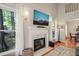 Close-up of the living room fireplace with mounted TV and a large window with natural light at 4969 Royal Adelaide Way, Raleigh, NC 27604